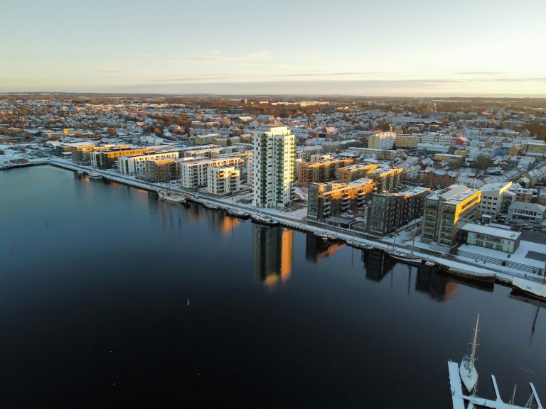 Aerial of snowy Karlstad cityscape reflecting in the water, Sweden